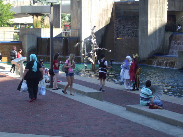 Anime girls being photographed at a fountain at the Otakon anime and manga conference in Baltimore.