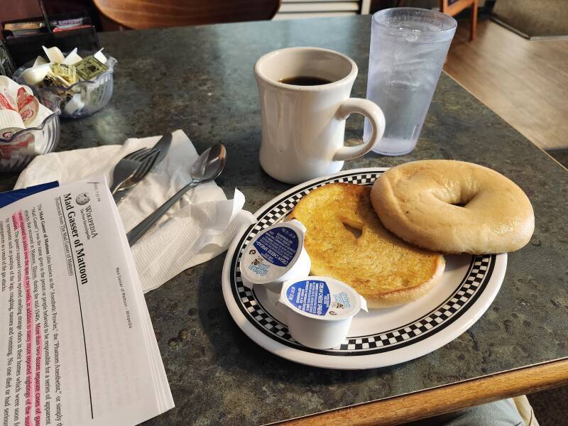 Bagel toasted with butter, cream cheese, and coffee.