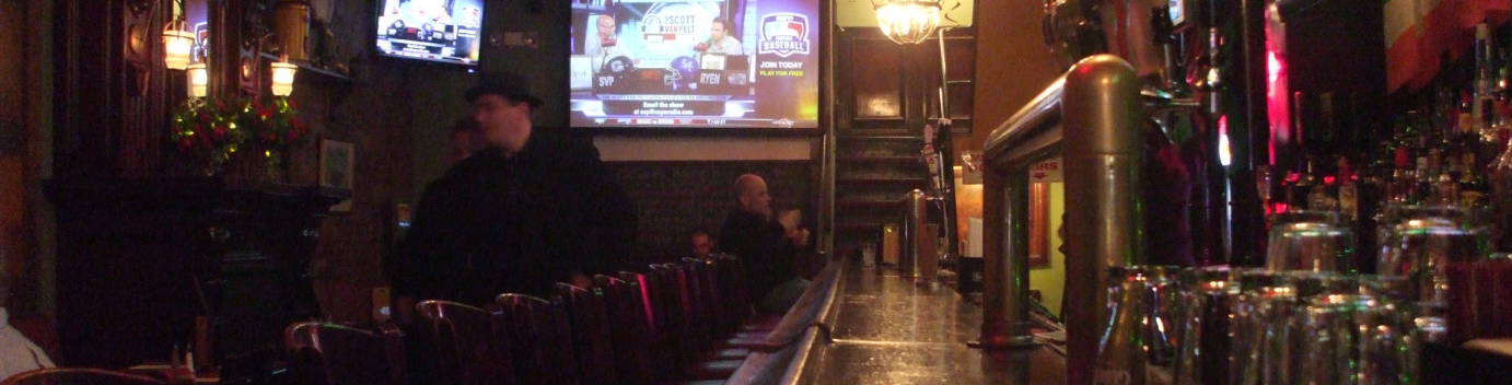 Interior of McGee's bar in New York, model for MacLaren's bar in 'How I Met Your Mother'.  Looking down the bar on the first floor: bar stools, booths at left, sports on flat-screen TVs, taps and glasses.