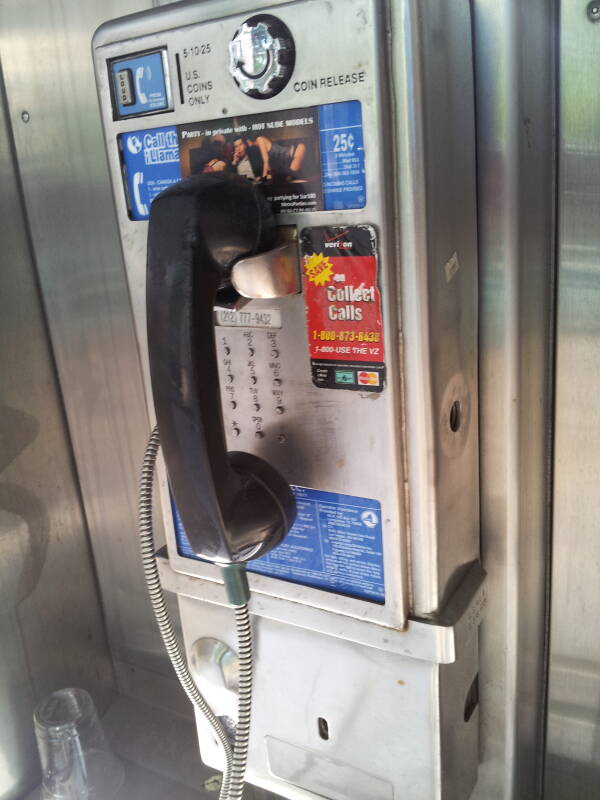 Relatively modern phone booth, enclosure starts about waist-high, relatively, small pin buttons.