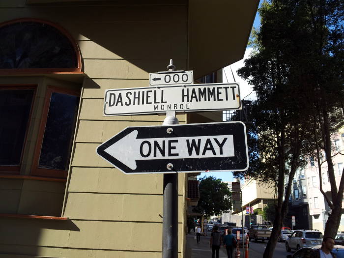 A sign indicates where to turn into Dashiell Hammett Way.