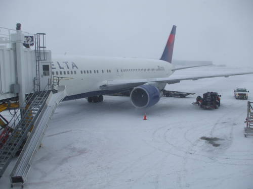 Snow covered B737 parked on the ramp.