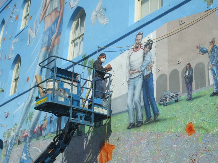 Artist adding to the mural.